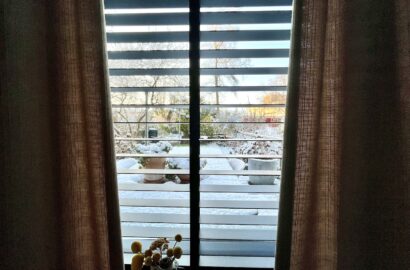 Aandacht op de tuin vanuit slaapkamer, met gordijnen als soort coulissen.