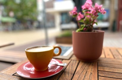 cappuccino met bloemetje op tafel op terras