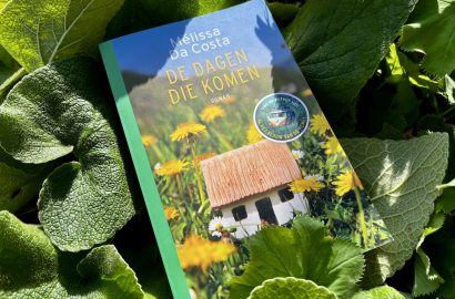 De dagen die komen, boek van Mélissa da Costa tegen een achtergrond van bladeren in een tuin