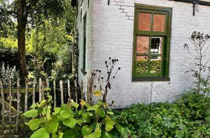 huis met tuin met septembergevoel waarin overgang van zomer naar herfst zichtbaar is