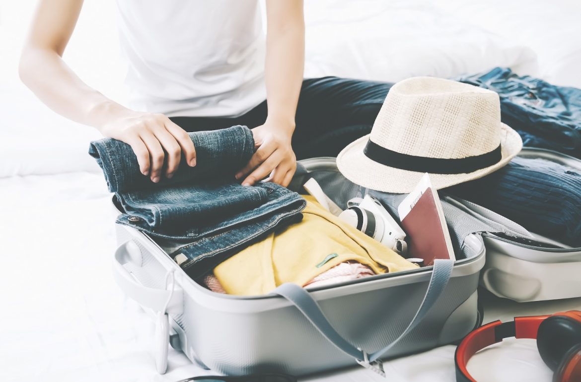een persoon die een koffer minimaal inpakt in het kader van licht reizen