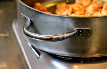 Close up van pan op het vuur voor het maken van een stoofpotje met blokjes pompoen