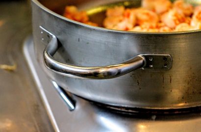 Close up van pan op het vuur voor het maken van een stoofpotje met blokjes pompoen