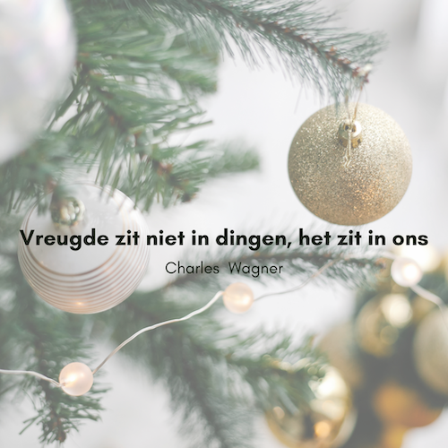 Quotes voor december tegen een achtergrond van kerstboom met ballen. Vreugde zit niet in dingen, het zit in ons
