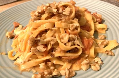 tagliatelle met tomaatjes, champignons en walnoten op bord