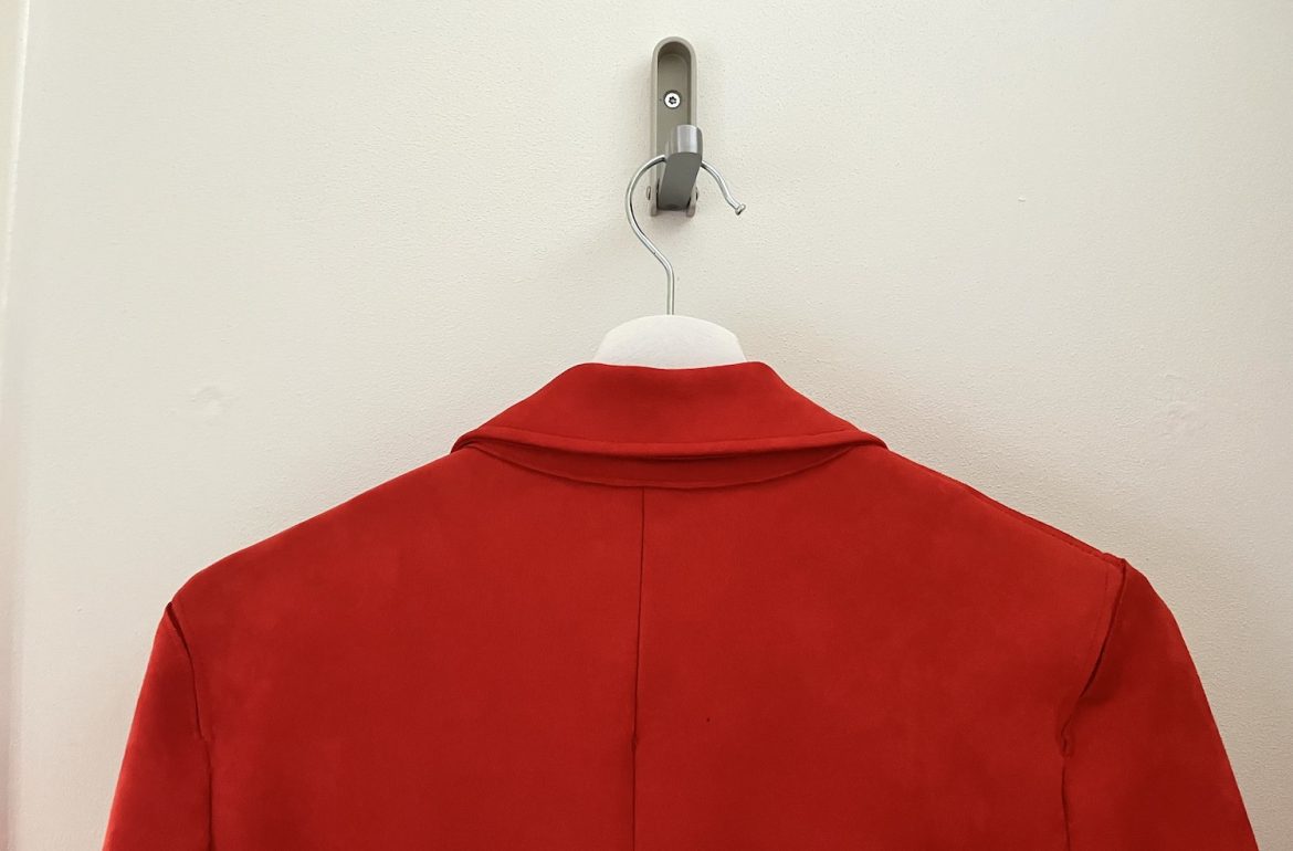 close up van rode jas bij blog over minimalistische kledingkast
