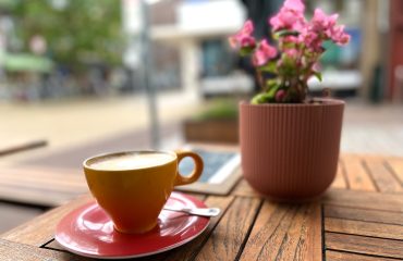 cappuccino met bloemetje op tafel op terras
