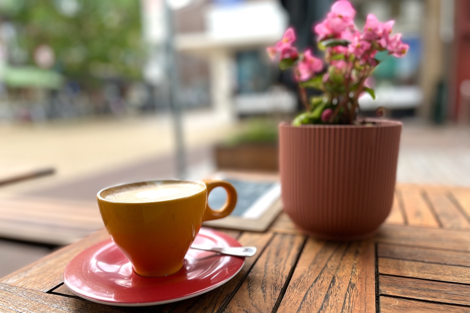 cappuccino met bloemetje op tafel op terras