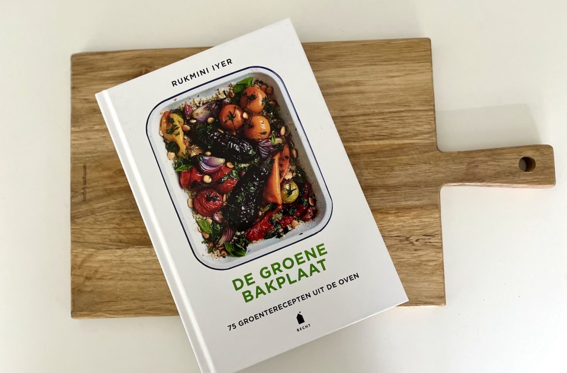 De Groene Bakplaat kookboek op een houten snijplank