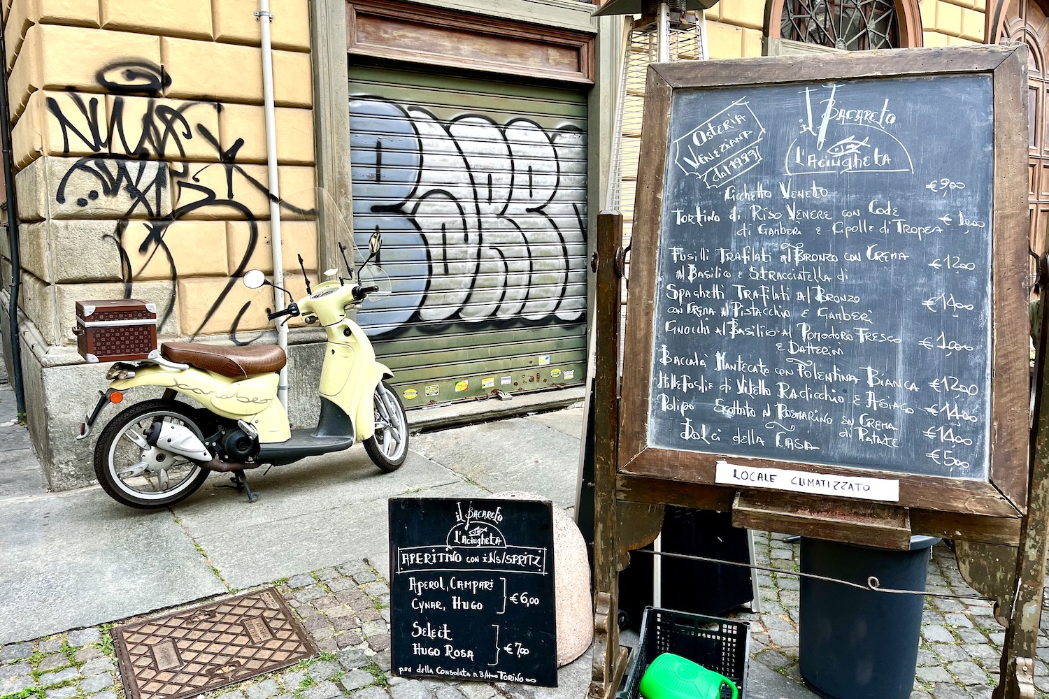 Pleintje met scooter en menukaart in Turijn