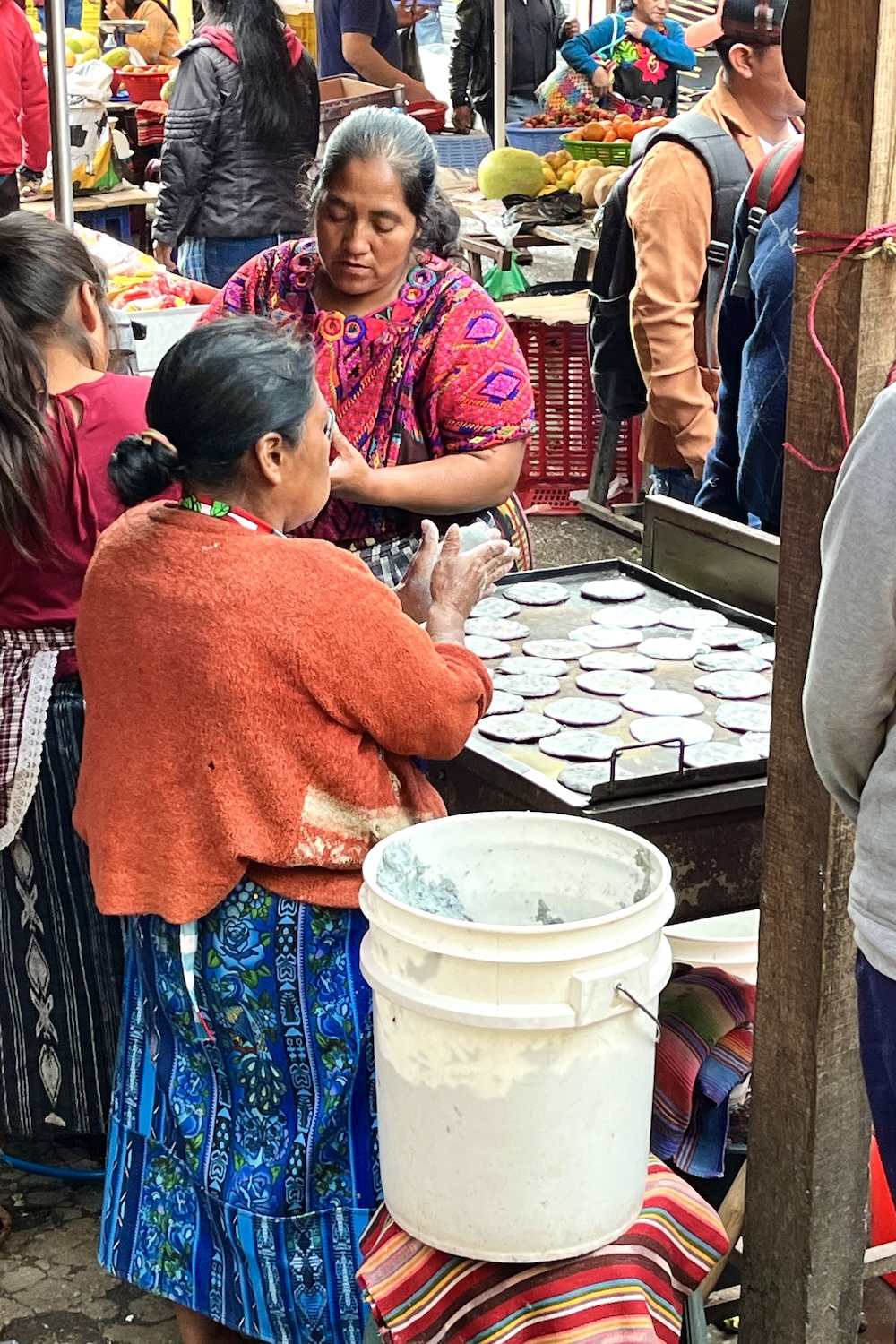 Vrouwen uit Guatemala bakken tortilla's op straat