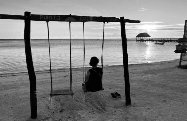 Janneke op schommel bij zonsondergang in Mexico bij blog over minimalisme in mijn leven.