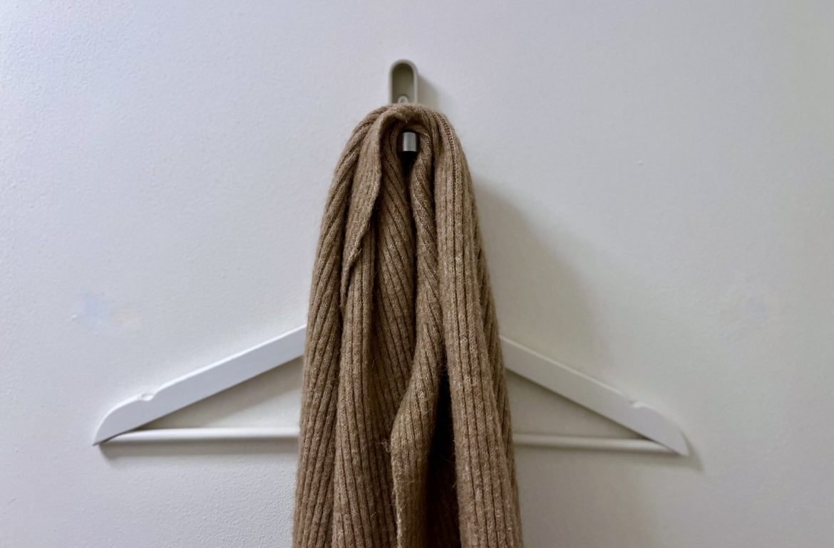 Witte kledinghanger op kapstok met sjaal, bij blog over minimalistische wintergarderobe