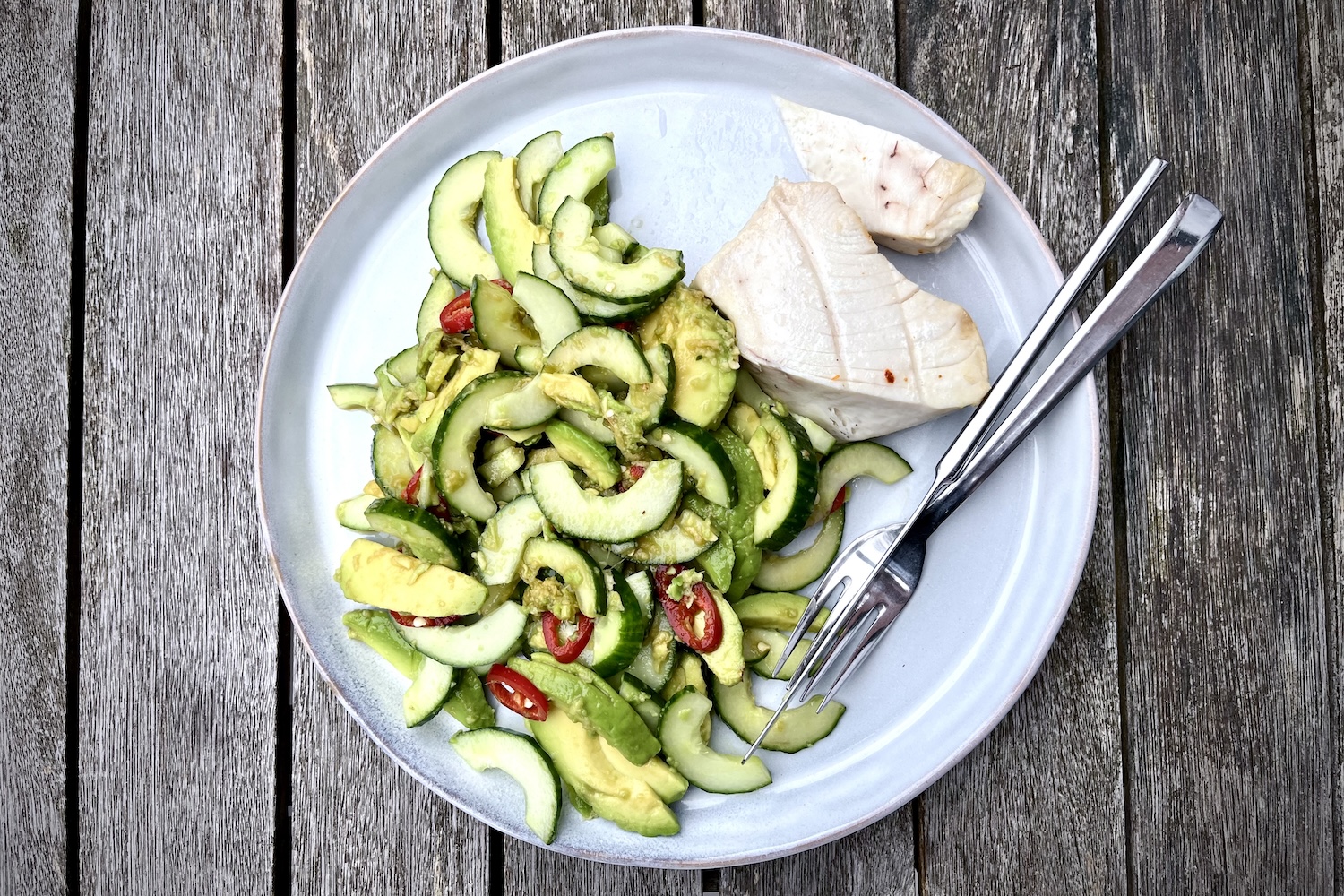 Gegrilde tonijnsteak met komkommer-avocado-gembersalade op een bord