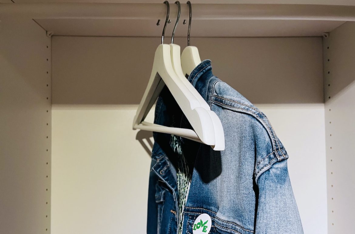 Een lege kast met drie hangers waarop een spijkerjasje hangt; tijd om te winkelen met een personal shopper. Bespaar tijd, geld en voorkom verspilling