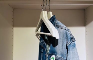 Een lege kast met drie hangers waarop een spijkerjasje hangt; tijd om te winkelen met een personal shopper. Bespaar tijd, geld en voorkom verspilling