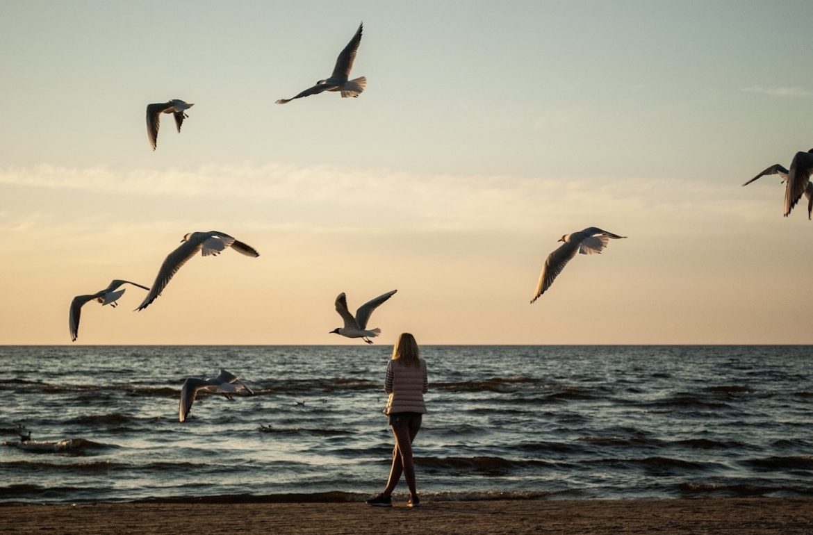 vrouw uitkijkend over zee; bij blog over het breken van een aantal gewoontes voor een betere mentale gezondheid