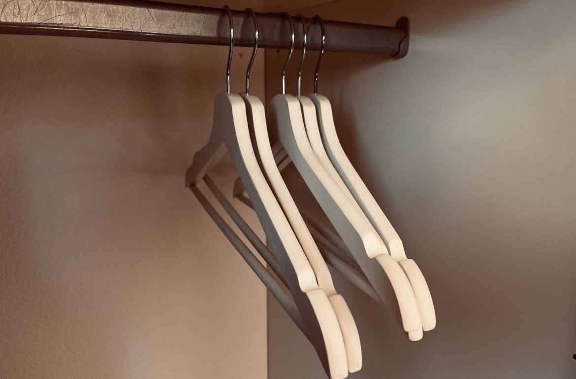 Kast met lege kledinghangers over artikel dat 33 kledingstukken mij rust geeft