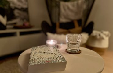 foto van interieur met boek, glas water, boek met stoel op achtergrond als fijne plek in donkere dagen